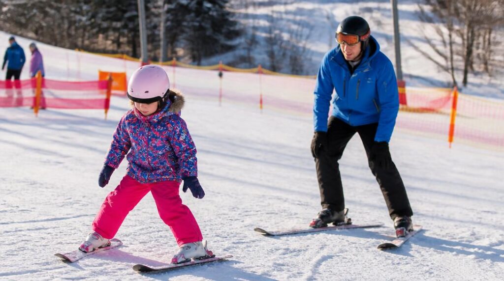 Enfant débutant en chasse-neige avec moniteur